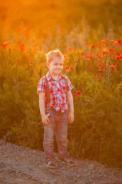 A funny young boy with eye misalignment, smiling and giggling in a sunset-lit Stock Photos