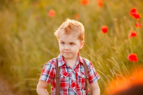 A funny young boy with eye misalignment, smiling and giggling in a sunset-lit Stock Photos