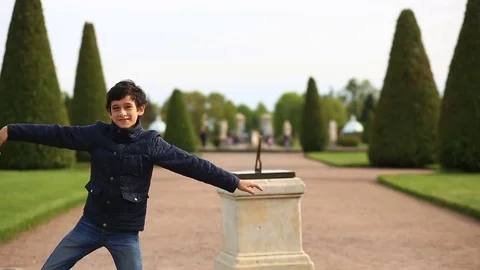 Funny young caucasian boy dancing on green grass lawn in park on summer sunny Stock Footage 76686152