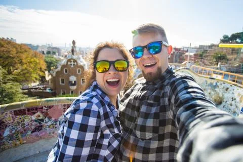 Funny young couple looking at camera taking photo with smart phone smiling in Stock Photos