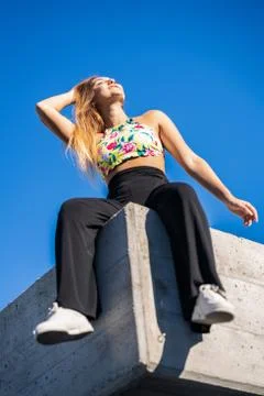 Funny young girl sitting on urban wall Stock Photos