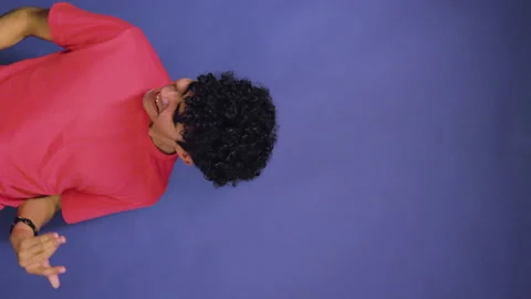 Funny young Hispanic playing an imaginary guitar and having a lot of fun in vert Vídeos de archivo 198948210