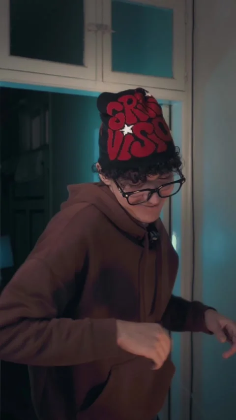 Funny Young Man Dancing Energetically in Blue Lit Studio with On Air Sign Stock Footage 325194048