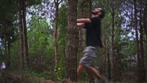 Funny Young Man magically pulls himself out of a tree in the forest Stock Footage 89984270