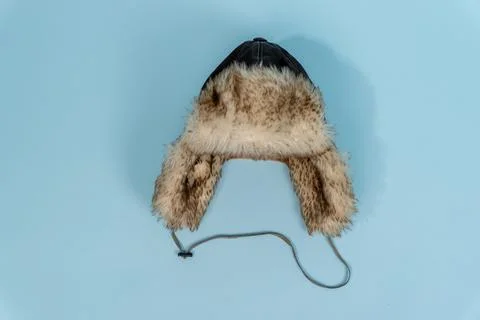 Fur-lined winter hat on light blue background Stock Photos