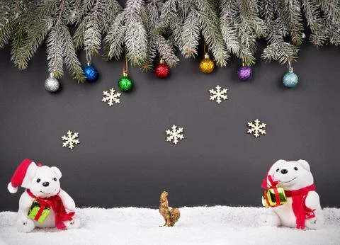 Fur-tree branches, balls, snowflake, rooster, presents and snow on gray backgrou Stockfoto's