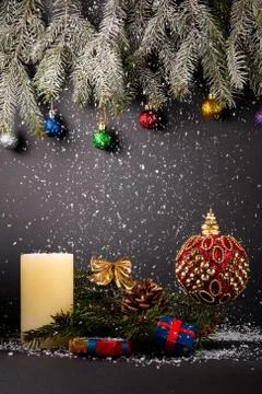 Fur-tree branches, cones, balls, candle, presents and snoflakes on black backgro Photos