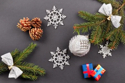 Fur-tree branches, cones, balls, candle, snowflake, on gray background Photos