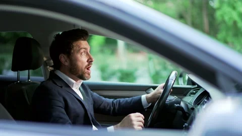 Furious angry man standing in a traffic jam beeps and hurries. Sitting  Video stock 246169890