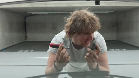 Furious car owner cannot understand what caused his vehicle to break down Stock Footage 343719500