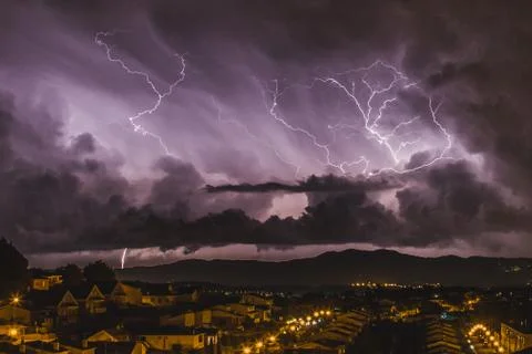 The furious lightning falling next to a quiet town. Magical lights and colour Photos