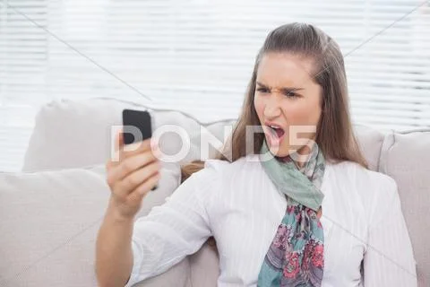 Furious pretty model screaming on the phone Stock Photos