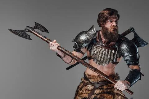 Furious viking armed with axe staring away prepared to attack Stock Photos