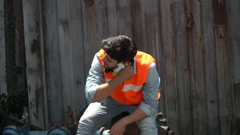 Furious young worker about to throw and break helmet and face mask at workpla Stock Footage 139095794