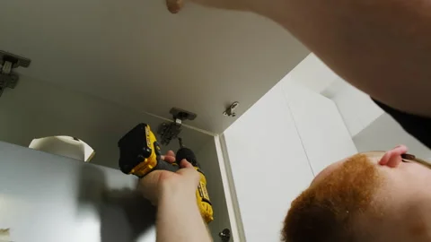 Furniture assembler installs hinge using screwdriver Video stock 316187465