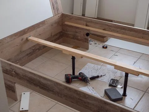 Furniture - assembling the bed, lying tools and wooden elements needed for wo Stock Photos