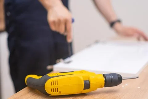 Furniture assembling process master tightening screw in wooden rack using Stock Photos
