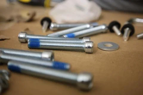 Furniture assembly bolts and tools on cardboard surface, close up hardware set f 写真素材
