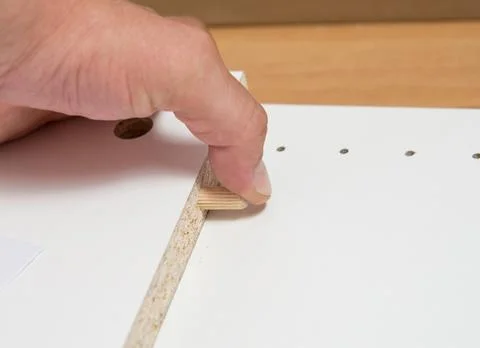 Furniture assembly concept. guy assembles wardrobe close up Stock Photos