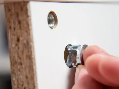 Furniture assembly concept. guy assembles wardrobe close up Stock Photos