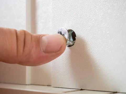 Furniture assembly concept. guy assembles wardrobe close up Stock Photos