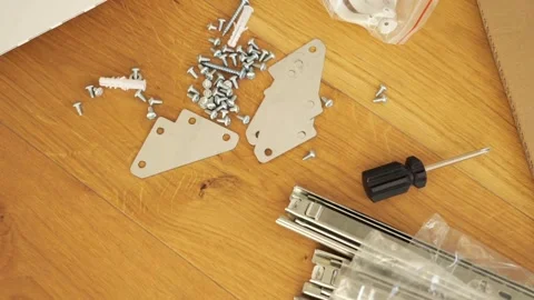 Furniture assembly tools and hardware laid out on wooden floor Stock Footage 319406158