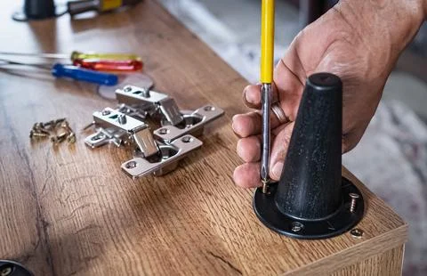 Furniture assembly. Work tool and components. Male Carpenter at work Stock Photos