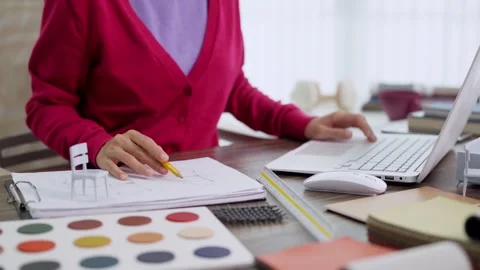 Furniture designer using laptop computer selecting color palette sample mat.. Stock Footage 336484196