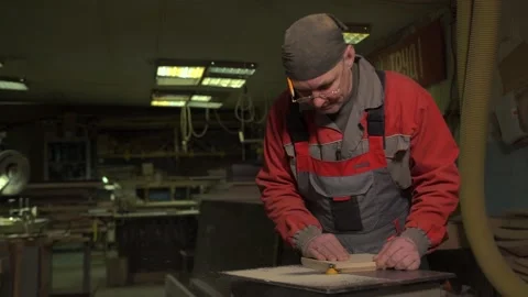 A furniture factory worker processes a block of wood for a set of products Stock Footage 149125537