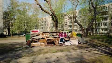 Furniture, junk, electronics thrown on the ground near garbage bins in an Video stock 275820843