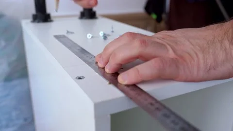 The furniture maker draws using a ruler and pencil on the cabinet body. Stock Footage 150244077