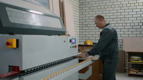 Furniture maker edges the edge of the part on a special stationary machine Stock Footage 219729672