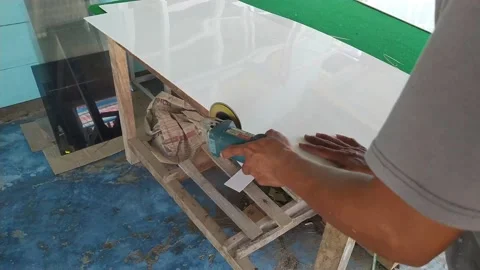 A furniture worker is using a griding tool to smooth the edges of plywood Stock Footage 206722451