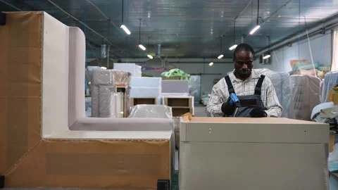 Furniture workshop worker uses electric stapler to attach upholstery fabric to Stock Footage 305612935