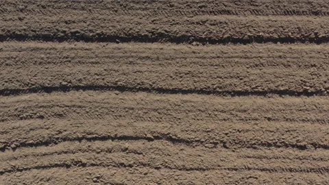 Furrows in the earth after plowing 4K aerial video Stock Footage 105308997
