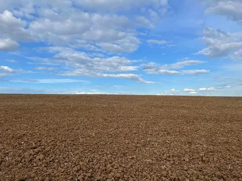 Furrows row pattern in a plowed field prepared for planting crops in spring.  Stock Photos