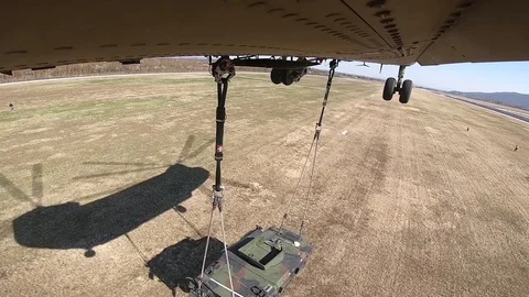 Fuselage view of CH-47 Chinook lifting Humvee sling load Video stock 105289488