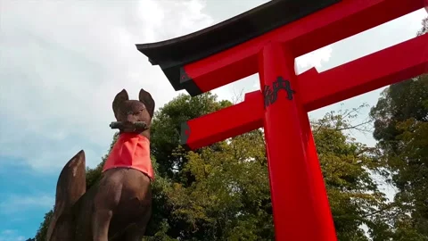 Fushimi Inari - Panning shot of Fox/kitsune Statue and Torii Gate Stock Footage