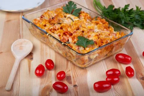 Fusili pasta baked with vegetables, tomatoes on a wooden table Stock Photos