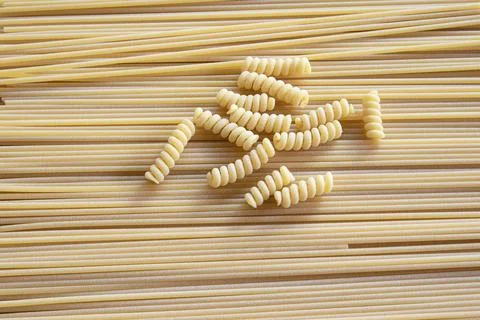 Fusilli and spaghetti dry pasta mix background texture Stock Photos