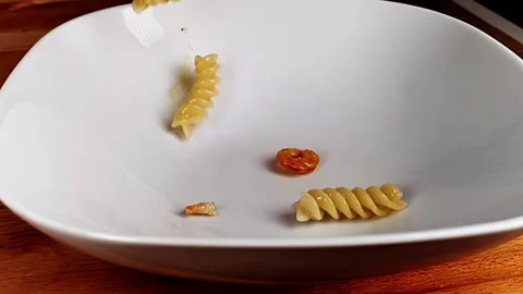 Fusilli falling into a plate with onion, shrimp and tomato Stock Footage 254778938