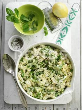 Fusilli with lemon, courgettes, peas and mint Stock Photos