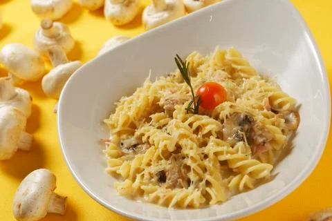 Fusilli or pasta spirals with ham, mushrooms and cherry tomato Stock Photos