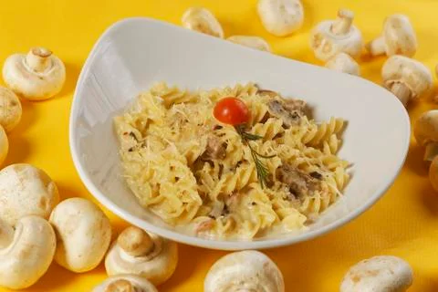 Fusilli or pasta spirals with ham, mushrooms and cherry tomato Stock Photos
