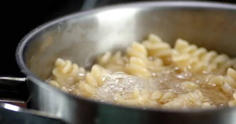 Fusilli pasta is boiled in boiling water in pan. Stock Footage 134186701