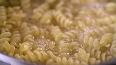 Fusilli pasta cooked in hot water, cooking in slow motion Video stock 121640337