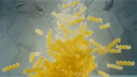 Fusilli pasta dropping into water 스톡 동영상 129609774