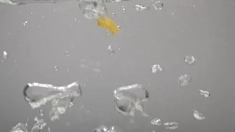 Fusilli pasta falls into boiling water, gray background, side view. Slow motion Stock Footage 124305961