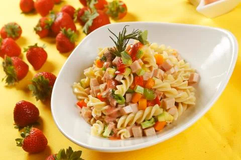 Fusilli pasta salad with ham, pumpkin, papaya, strawberry and broccoli. Stock Photos