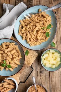 Fusilli pasta with sweet roasted semolina and cinnamon, served with pineapple Stock Photos
